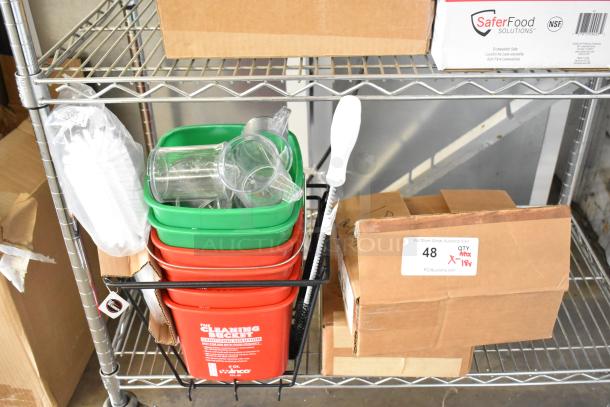 18 brand new scratch and dent items, including brushes, red and green poly bins. Items on a metal shelf with boxes.
