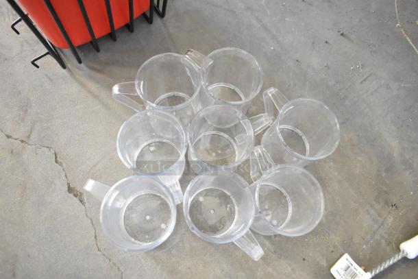 18 new scratch and dent items, including clear plastic pitchers and a poly bin, shown on a concrete floor.