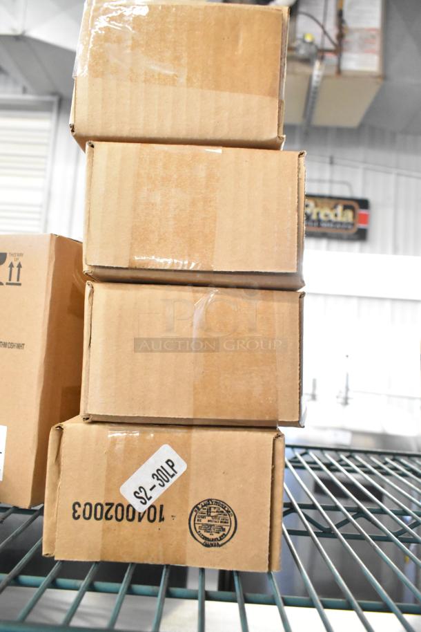 Stack of unopened boxes containing 12 new scratch and dent kitchen items, such as Carlisle lids and Taylor thermometer.