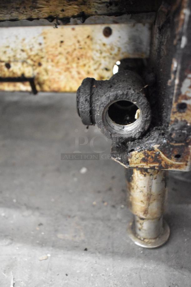 Garland commercial countertop gas charbroiler, heavily worn and dirty, showing rust and grease accumulation.