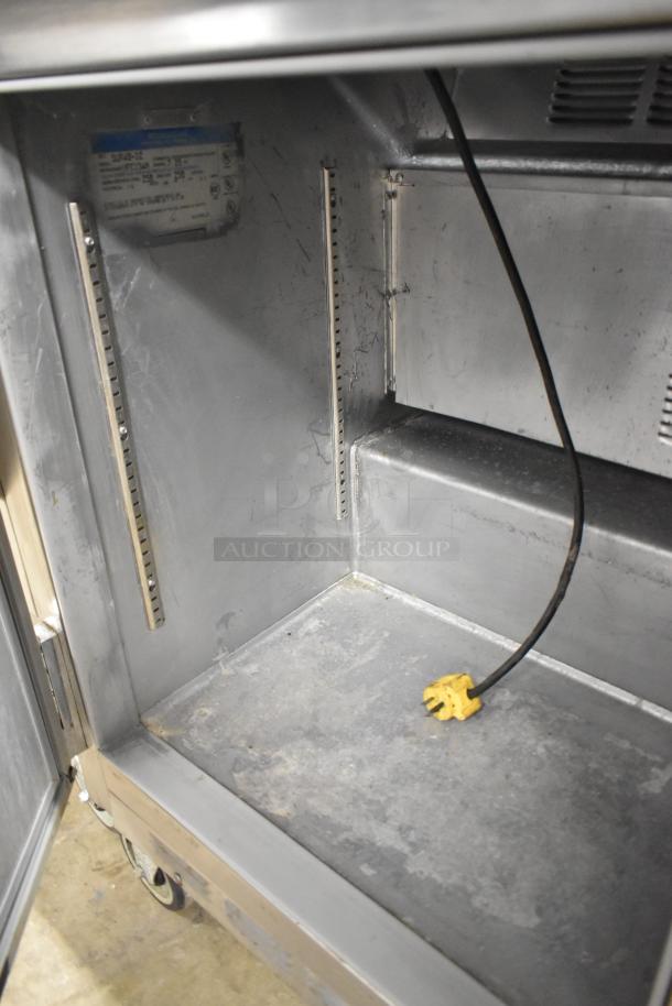 Beverage Air SUR48-12 commercial prep table, interior view with metal interior and power cord, on commercial casters.