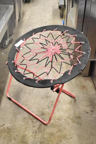 Folding net chair with a pink and black elastic seat design on a pink metal frame, in good condition.