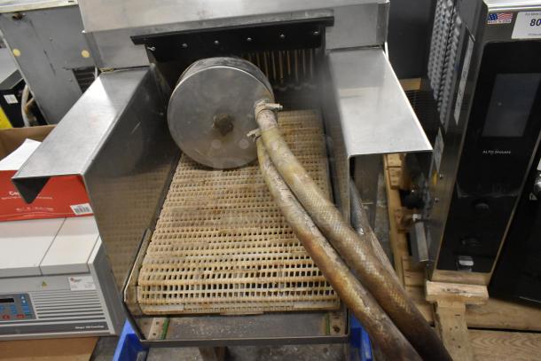 Pokomat P16/320 SI metal brine meat injection machine on casters. 220 volts. Used condition with visible hoses and grid surface.