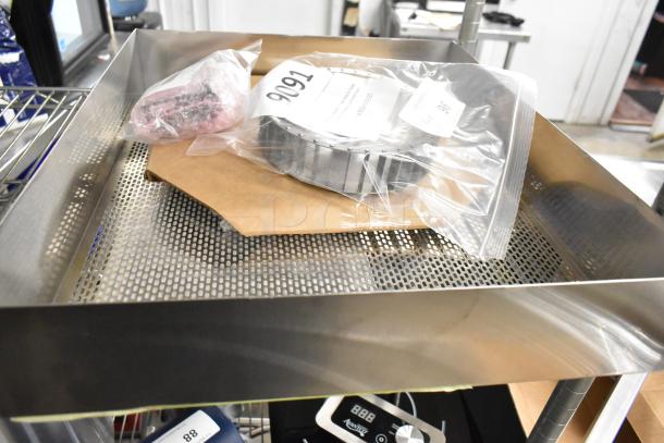 Four new scratch and dent items, including a Moffat 7" fan blade and Polar Temp controller, packaged, on a metal shelf. Tags visible.