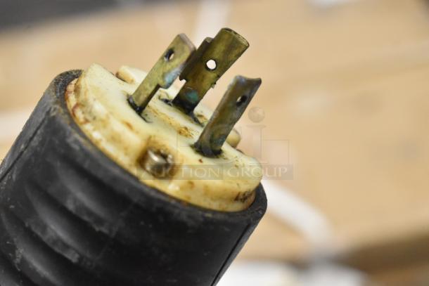 Close-up of electrical connection from popcorn kettle with visible wear and oxidation on prongs, suitable for popcorn machines.