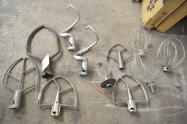 11 mixer attachments: pastry, 4 paddles, 3 dough hooks, 3 whisks, metal, varied condition. Auction item, number label visible.