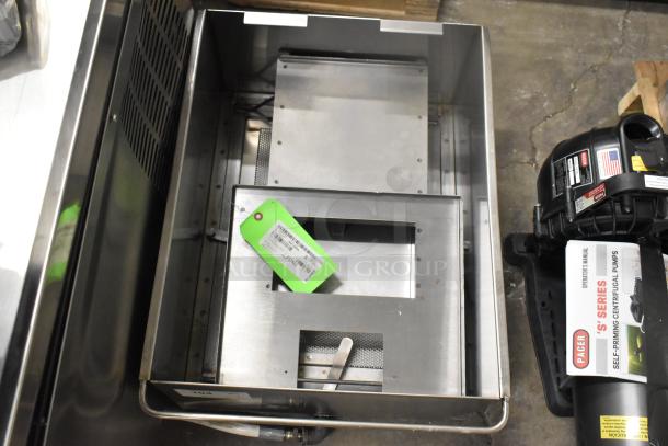 Brand new grease trap with 2025 Frymaster 1080437 flue assembly, minor scratches, green tag with item details visible.