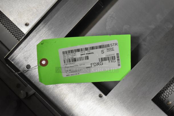 Brand new oil grease trap with 2025 Frymaster 1080437 flue assembly. Green tag shows shipping and product details. Minor scratches.