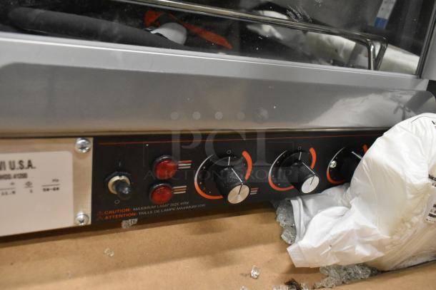 Hatco GRHD-4PD merchandiser control panel showing knobs and labels. Note glass damage nearby. White granite stainless steel.