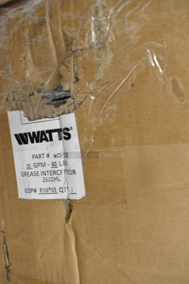 Cardboard box with visible Watts label showing details for a WD-20 Grease Interceptor, 40 lbs, 20 GPM. Box is slightly damaged.