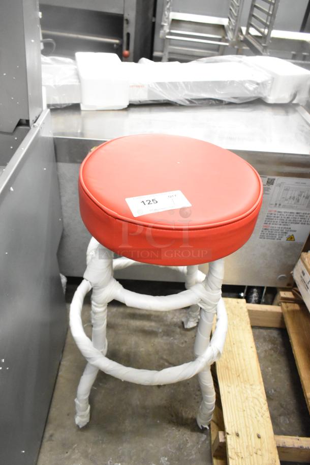 Black metal stool with red seat cushion, brand new, slight scratches, protective wrap on legs, label "125" visible.