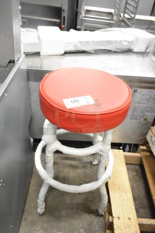 Black metal stool with red seat cushion, brand new, slight scratches, protective wrap on legs, label "125" visible.