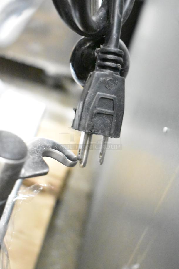 Close-up of Avantco 177MX10H dough mixer power plug and metal whisk attachment. Item is new, 120 volts, shows minor scratches.