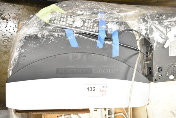 12 various items including Marquette MAC1200 EKG Machine and metal pieces, shown with protective wrap and labeled tag for auction.