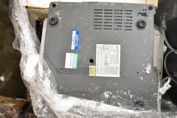 Various items including a Marquette MAC1200 EKG machine and metal pieces. Labels indicate Bionet Co. Ltd with model info.