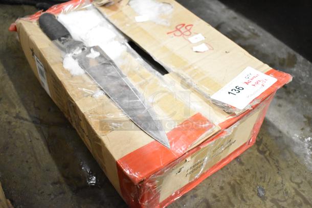 Box of 120 sharpened stainless steel knives, including a chef knife, with red tape and auction tag numbered 136.