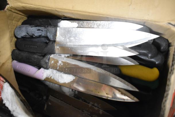 Box of 120 sharpened stainless steel knives, including chef knives, with mixed handle colors, showing visible wear.