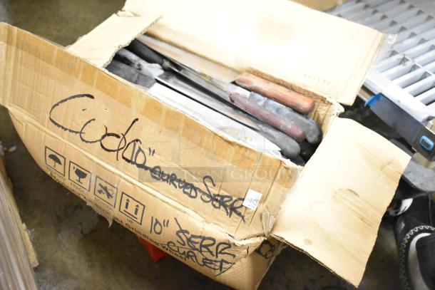 Box of sharpened stainless steel knives, including chef knife, assorted handles. Marked with "10" SERR CURVED." Box slightly worn.