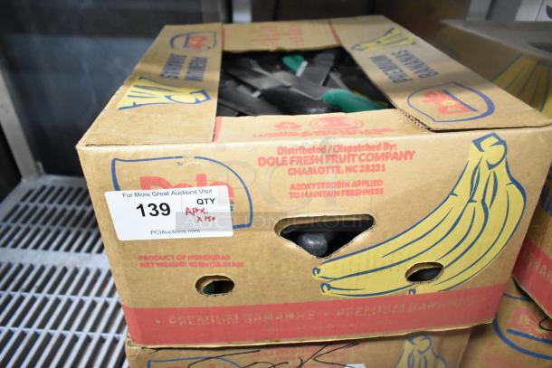 Box of 150 sharpened stainless steel knives, including chef knives, in cardboard container. Auction label indicating quantity.