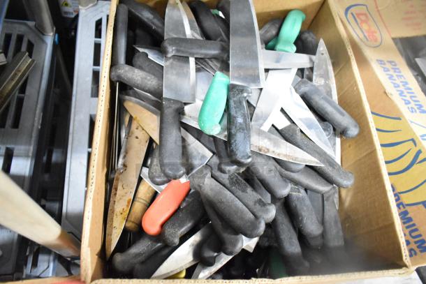 Box of 150 sharpened stainless steel knives with black, green, and red handles, including chef knives, in used condition.