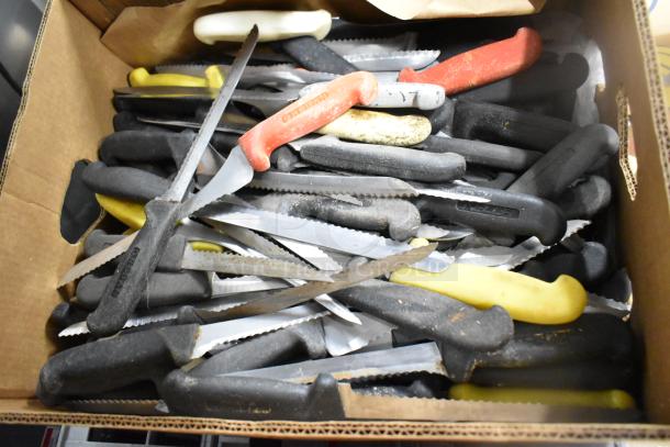 Box of 200 sharpened stainless steel knives with mixed colored handles, including chef and serrated knives.