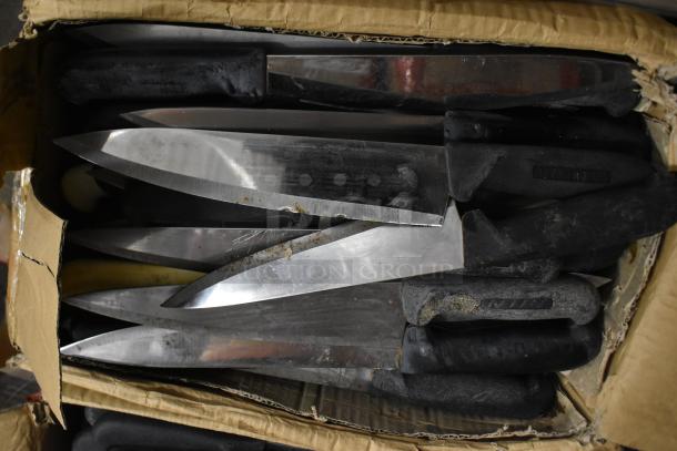 Box of 85 sharpened stainless steel knives, including chef knives, in worn condition with black handles.