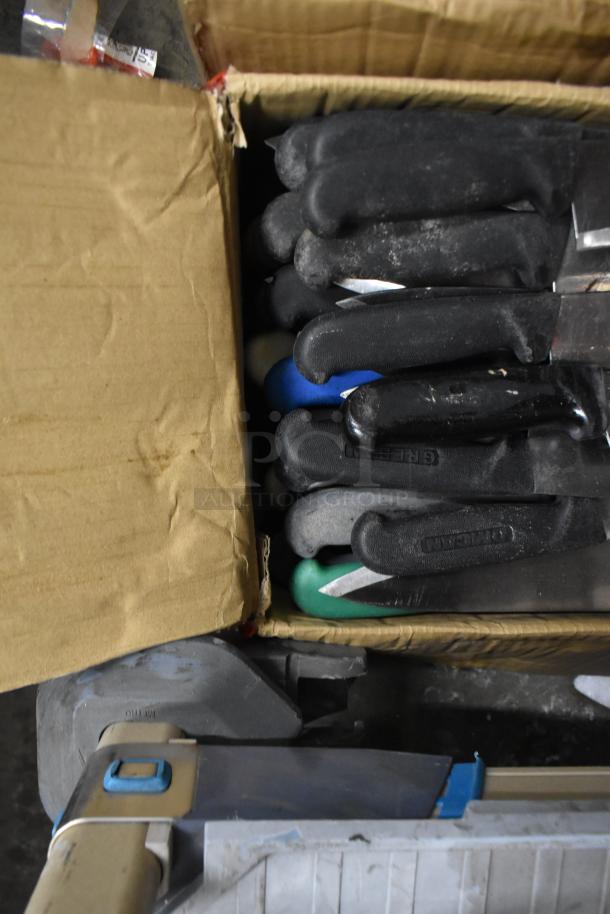 Box of 85 sharpened stainless steel knives, including chef knives, with black handles. Various brands visible.