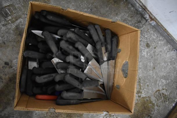 Box of 150 sharpened stainless steel knives, including chef knives, with black handles. Suitable for commercial use.