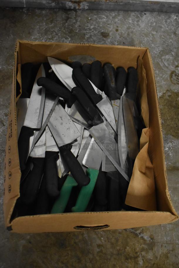 Cardboard box containing 150 sharpened stainless steel knives, including chef knives, with black and green handles, good condition.