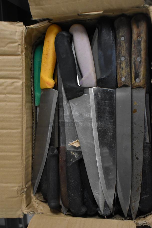 Box of 150 sharpened stainless steel knives, various handles, includes chef knife, used condition, ideal for bulk purchase.