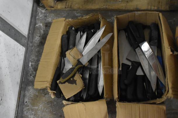 Two boxes of 150 sharpened stainless steel knives, including chef knives, with black handles, in good condition.
