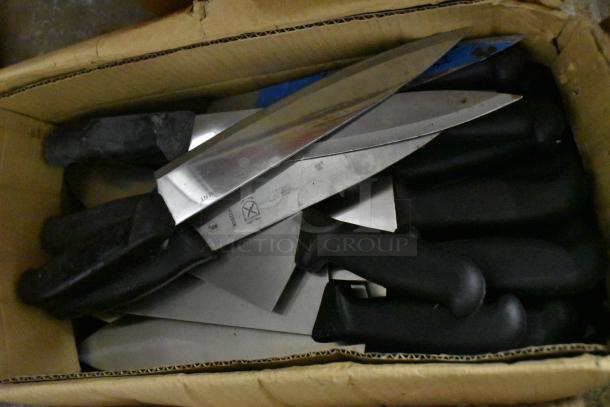 Box of sharpened stainless steel knives, including chef knives. Black handles, visible blade markings, excellent condition.