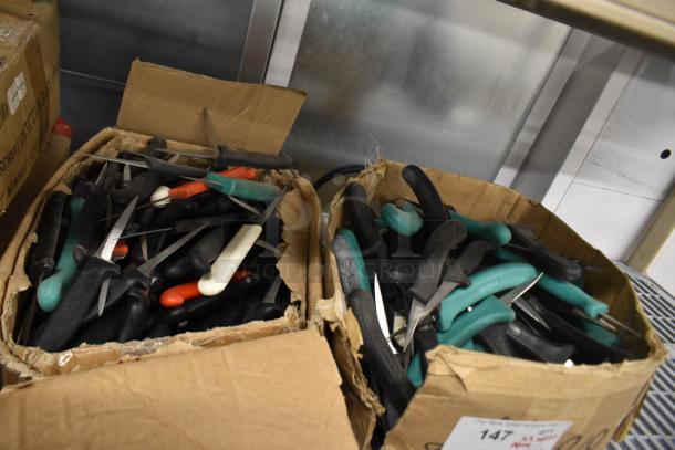 Boxes containing 200 sharpened stainless steel knives, including poultry and paring knives, with varied handle colors.