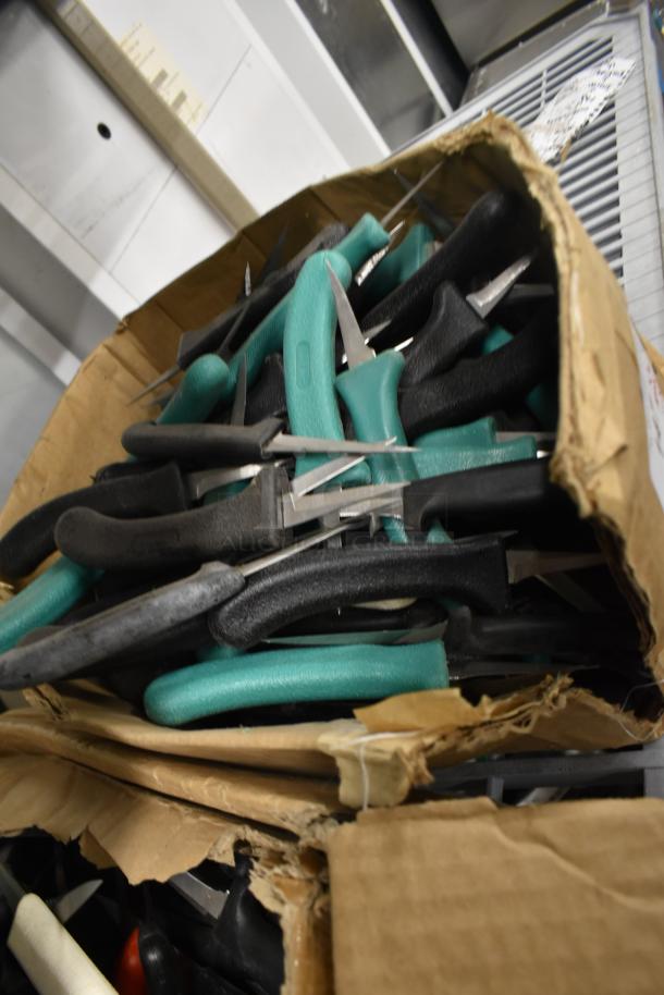 Box of 200 sharpened stainless steel knives, including poultry and paring knives, with various black and green handles.