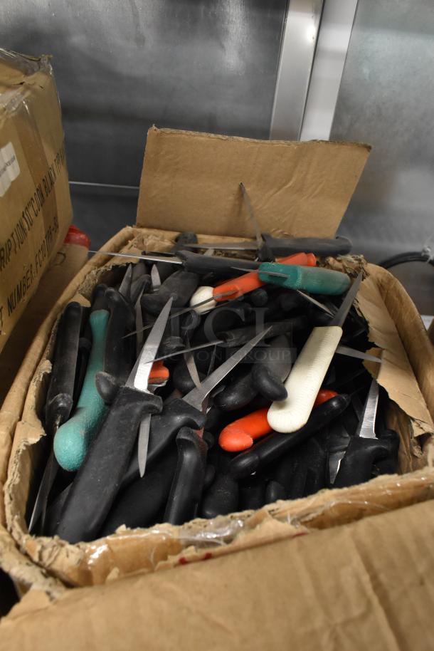 Cardboard box containing 200 sharpened stainless steel knives, including poultry and paring knives, with various handle colors.
