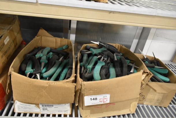 Boxes of 250 sharpened stainless steel knives with green and black handles, including poultry knives.