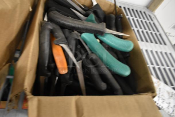 Box of 250 sharpened stainless steel knives with various black, orange, and green handles, including a poultry knife.