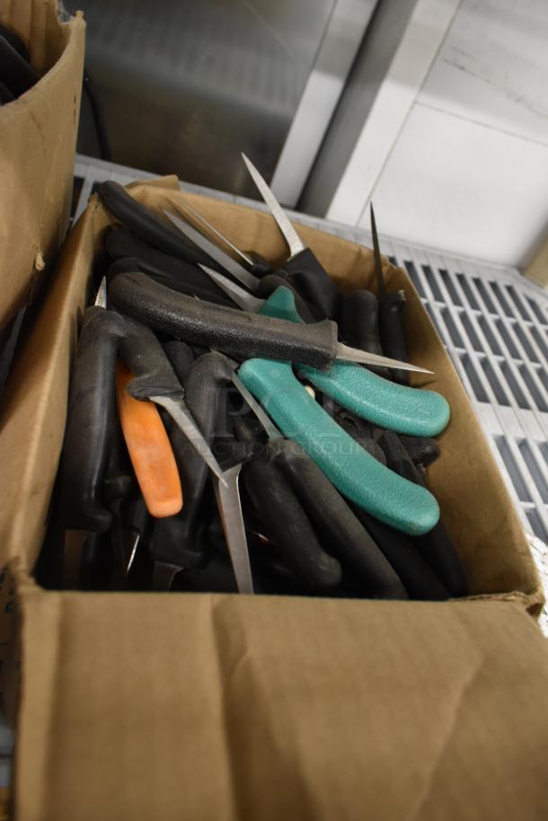 Box of 250 sharpened stainless steel knives with black, orange, and green handles, including poultry knife.