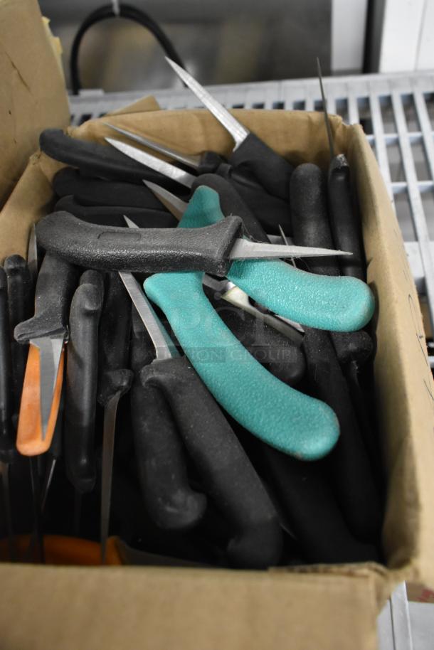 Box of 250 sharpened stainless steel knives, including various types. Black, green, and orange handles visible.