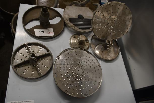 12 various blades for Pelican Head Slicer, including grating and slicing blades. Item has auction label "149, QTY 12".