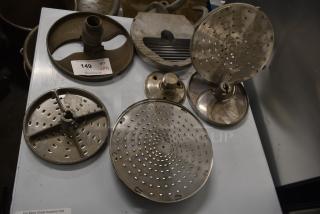 12 various blades for Pelican Head Slicer, including grating and slicing blades. Item has auction label "149, QTY 12".