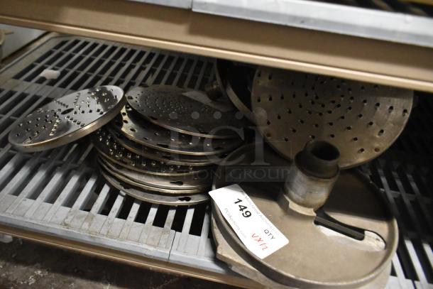 12 various blades for Pelican Head Slicer, including grating and slicing blades, on metal rack, item label "749 QTY VX12".