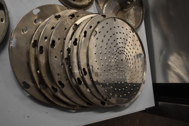 12 metal blades for Pelican Head Slicer, includes grating and slicing types, stacked, showing various hole patterns.