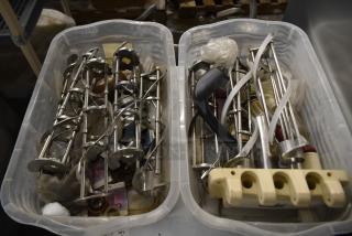 Two bins with various ice cream machine parts, including metal augers and a front panel. Multiple loose components.