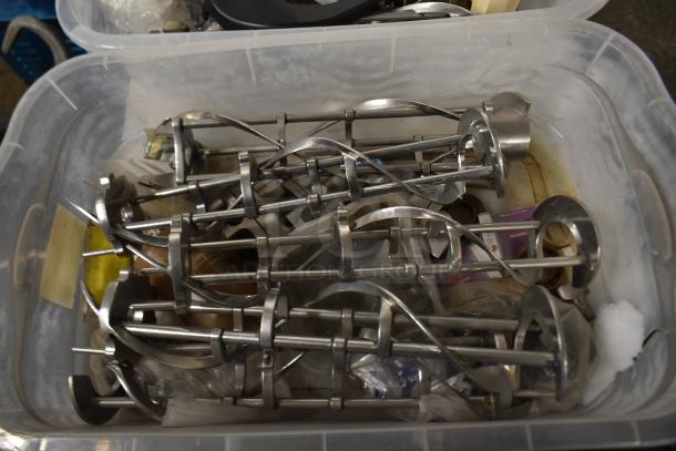 Two bins filled with various ice cream machine parts, including metal augers and a front panel, suitable for equipment repairs.
