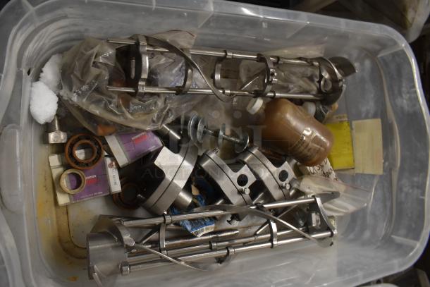 Two bins filled with assorted ice cream machine parts, including metal augers and a front panel, for auction.