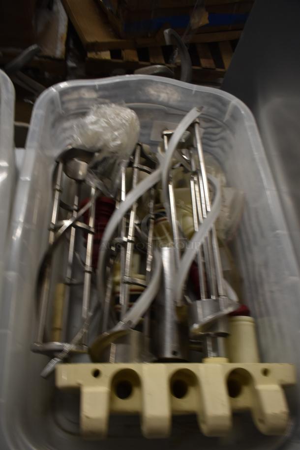 Two bins of assorted ice cream machine parts, including augers and a front panel, in used condition.