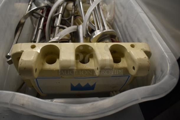 Two bins containing various ice cream machine parts, including augers and a front panel, in used condition.