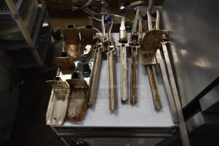 Seven commercial can openers with mounts, varying condition. Rust and wear visible, suitable for heavy-duty kitchen use.