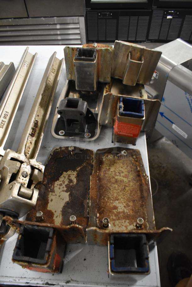 Seven commercial can openers with mounts, showing signs of rust and wear. Includes size markings and warning labels.